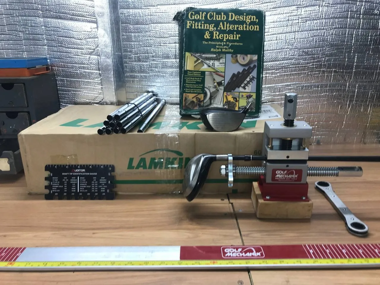 Golf shaft removal and fitting tools on a repair bench